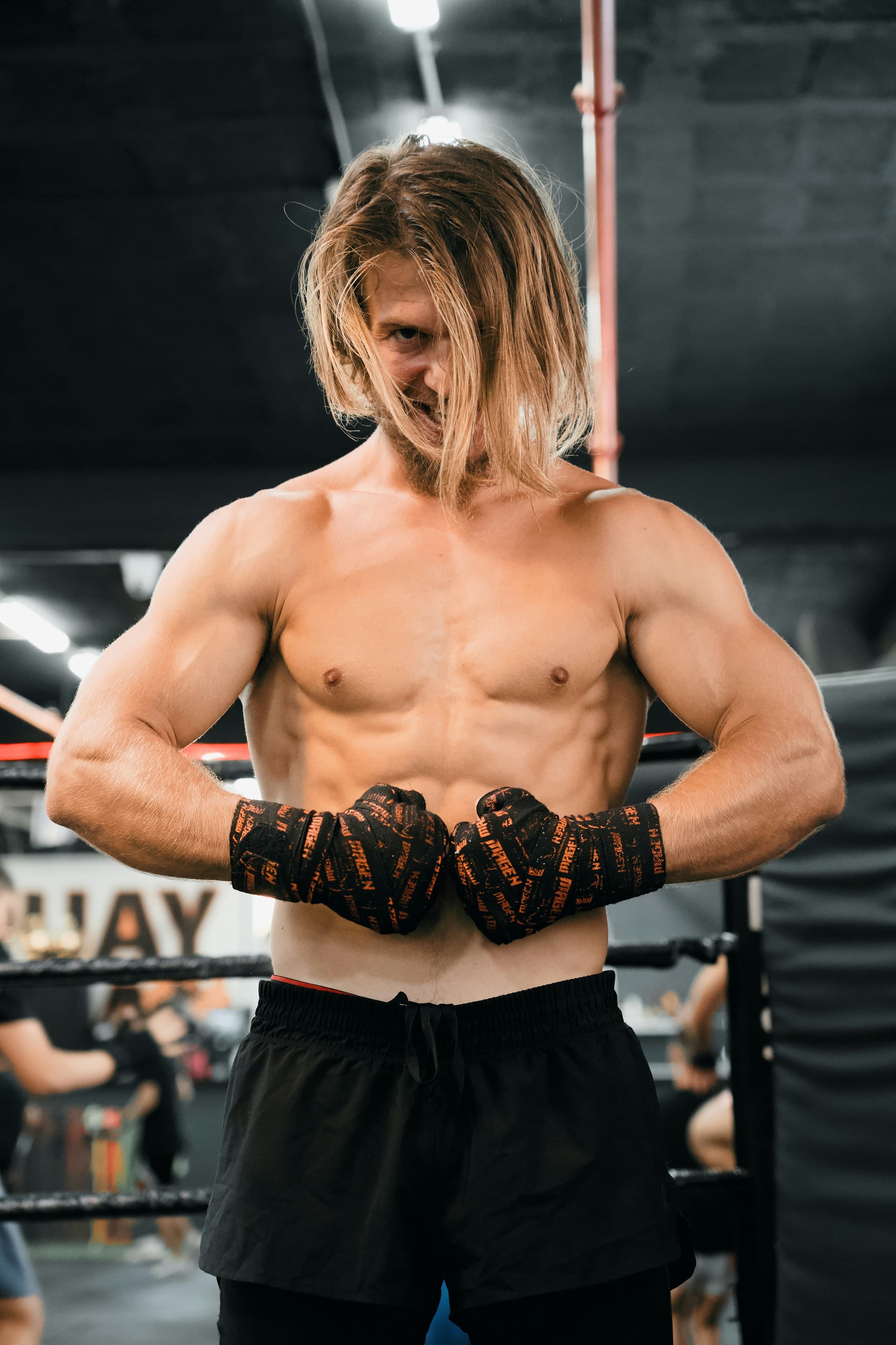 Un boxeur torse nu debout sur un ring